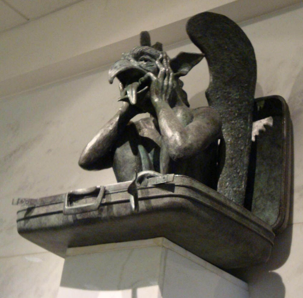 Gargoyle sits in suitcase sticking his tongue out at the Denver New World Airport DIA